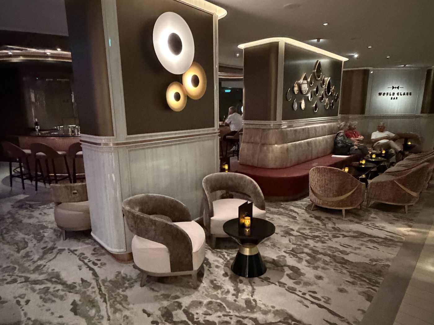 The World Class Bar, a low-lit lounge with sculptural lighting, velvet armchairs and a marbled carpet