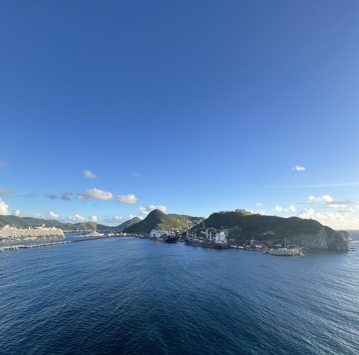 The ship’s wake on deep blue water, leaving an island port behind