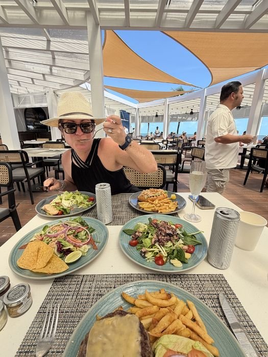 A table set for lunch outdoors at Ocean House on Ocean Cay, with shrimp and conch fritters, a rock shrimp salad and a lobster roll