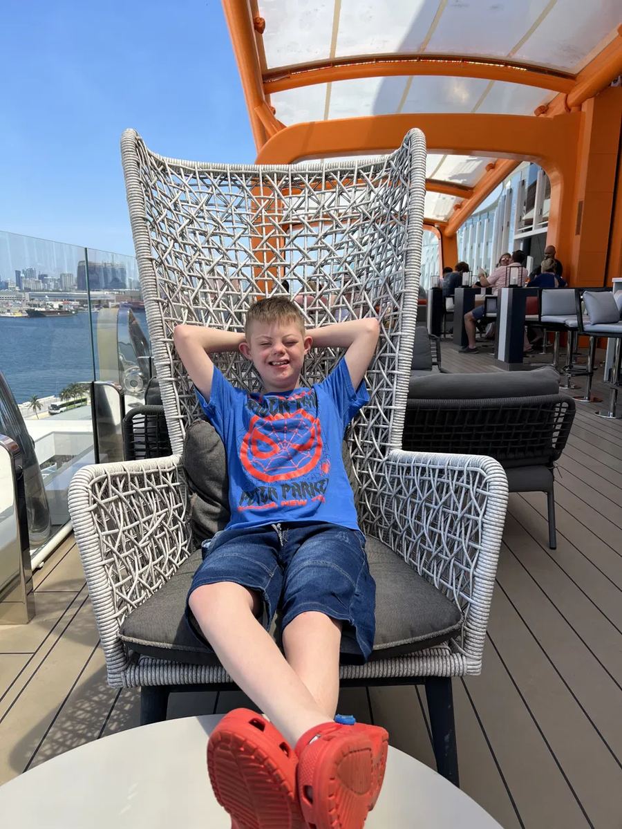 Jaxon relaxing in a chair on a cruise ship deck before trying the FlowRider.