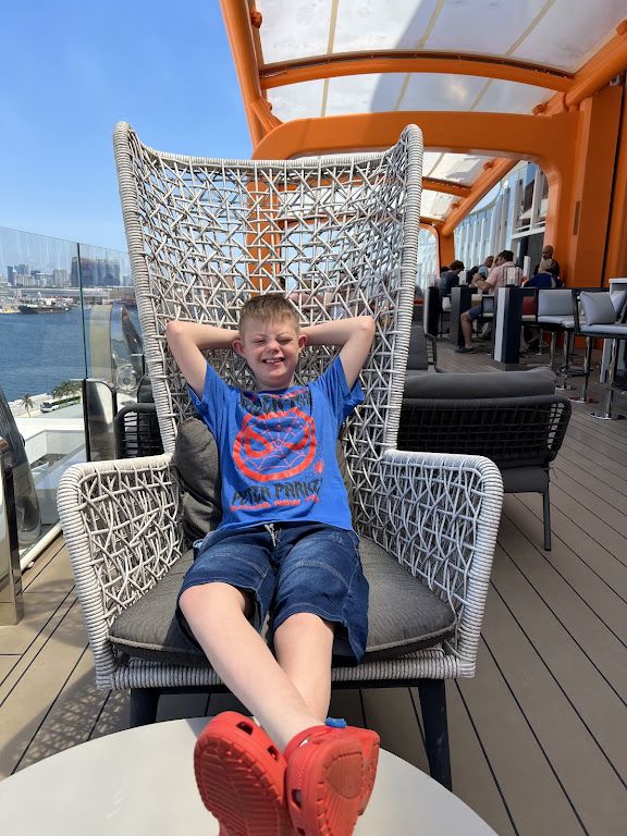 Jaxon relaxing in a chair on a cruise ship deck before trying the FlowRider.